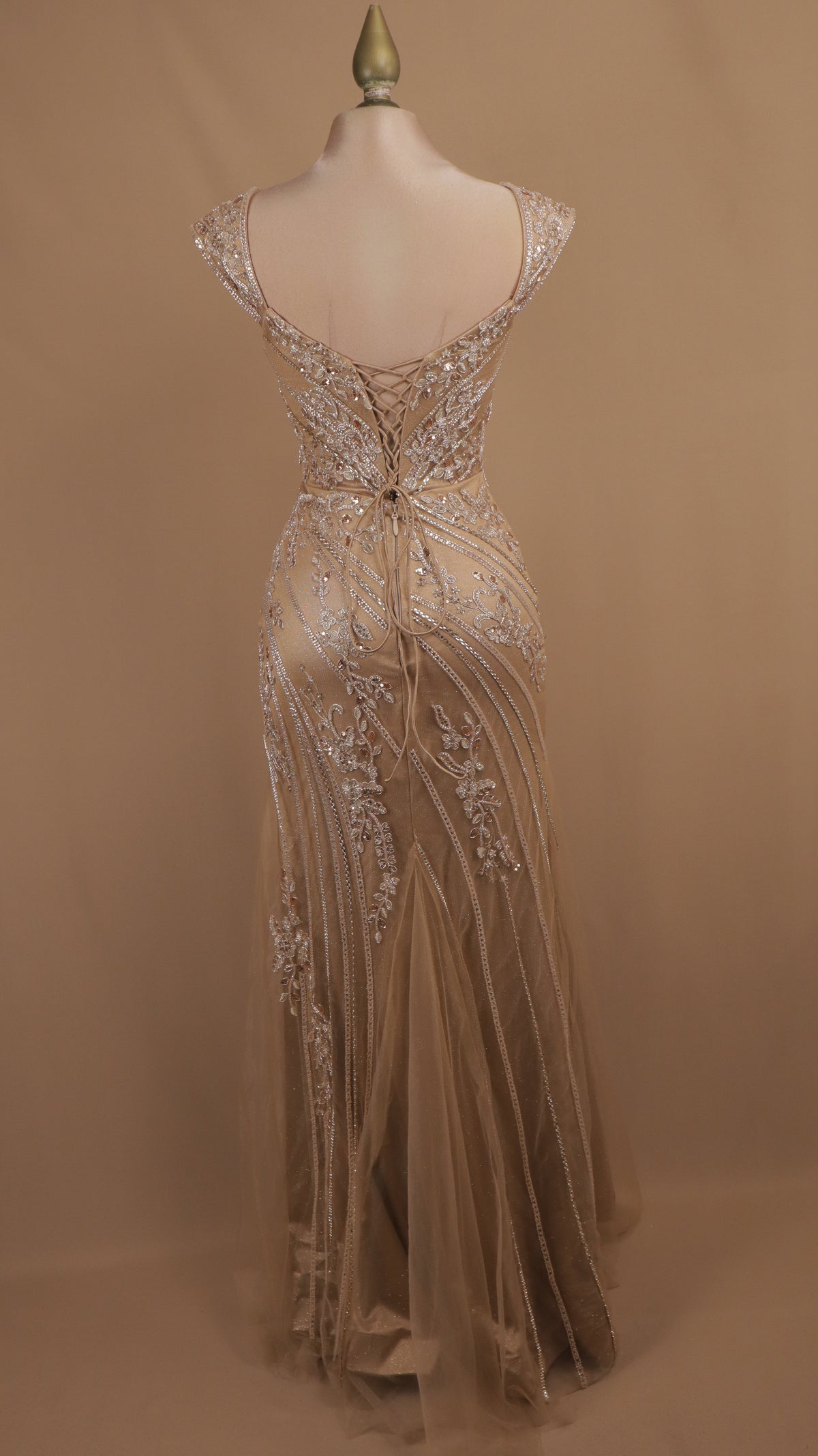 Vestido de noche largo corte sirena con corsé de pedrería y abertura en la pierna.