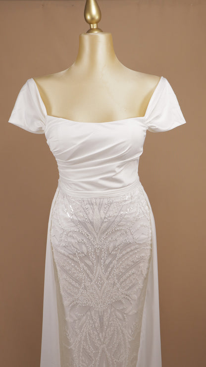 Vestido de novia corte columna con sobrefalda y pedrería geométrica