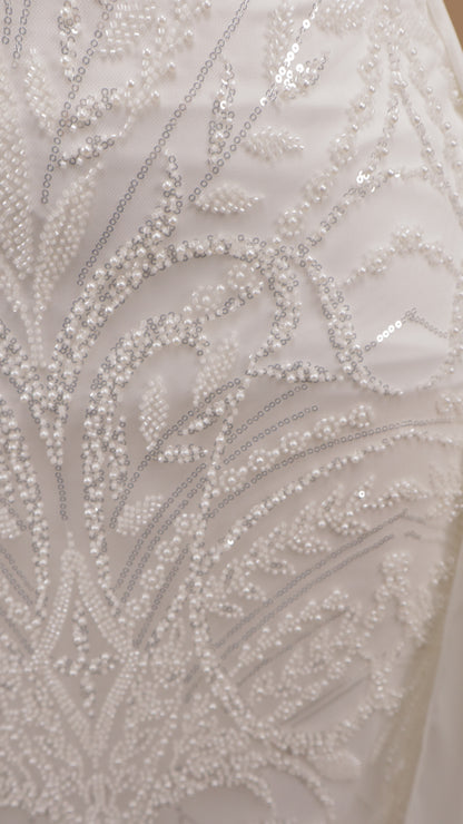 Vestido de novia corte columna con sobrefalda y pedrería geométrica