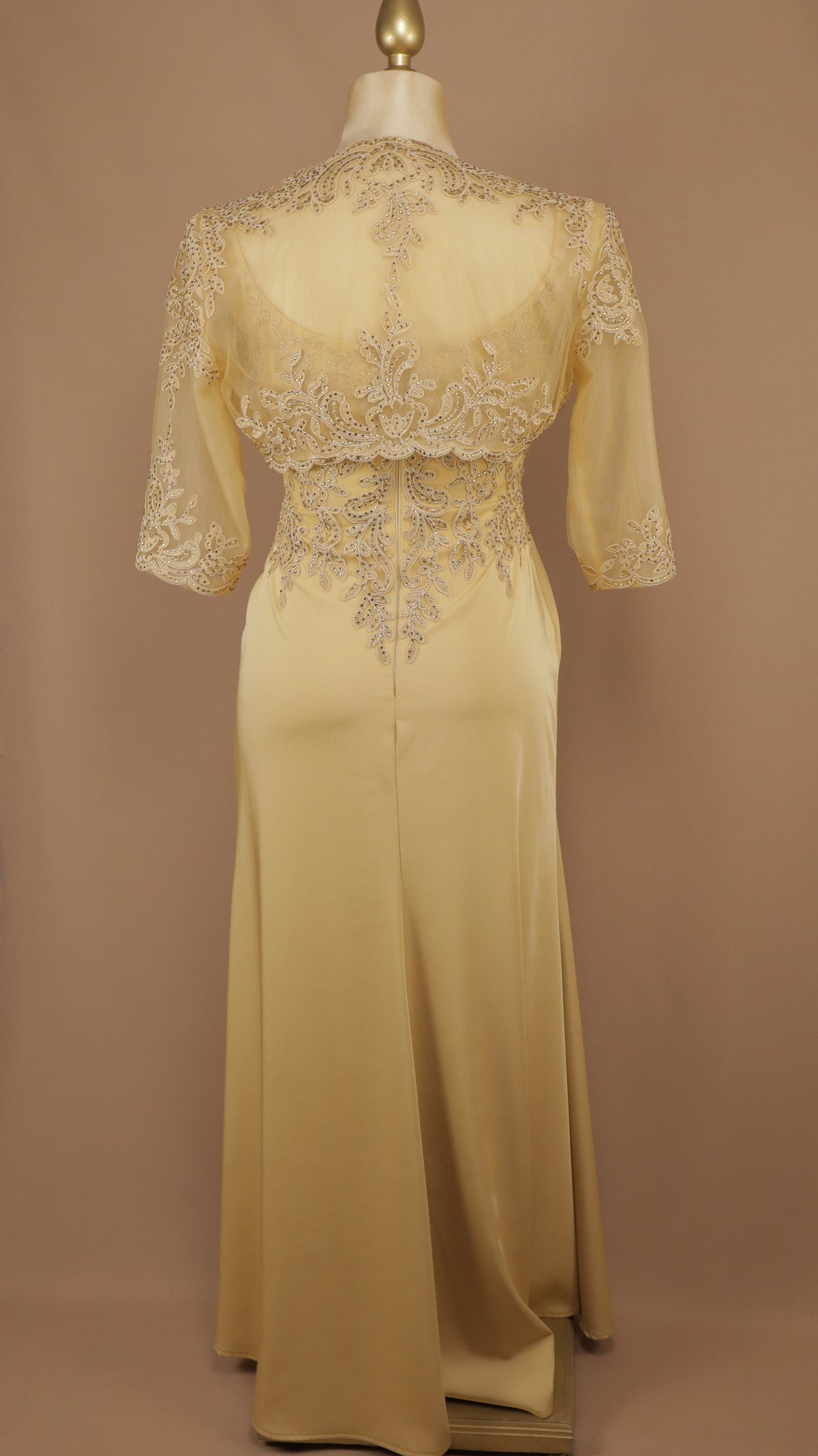 Vestido de gala en corte columna con torera de encaje desmontable.