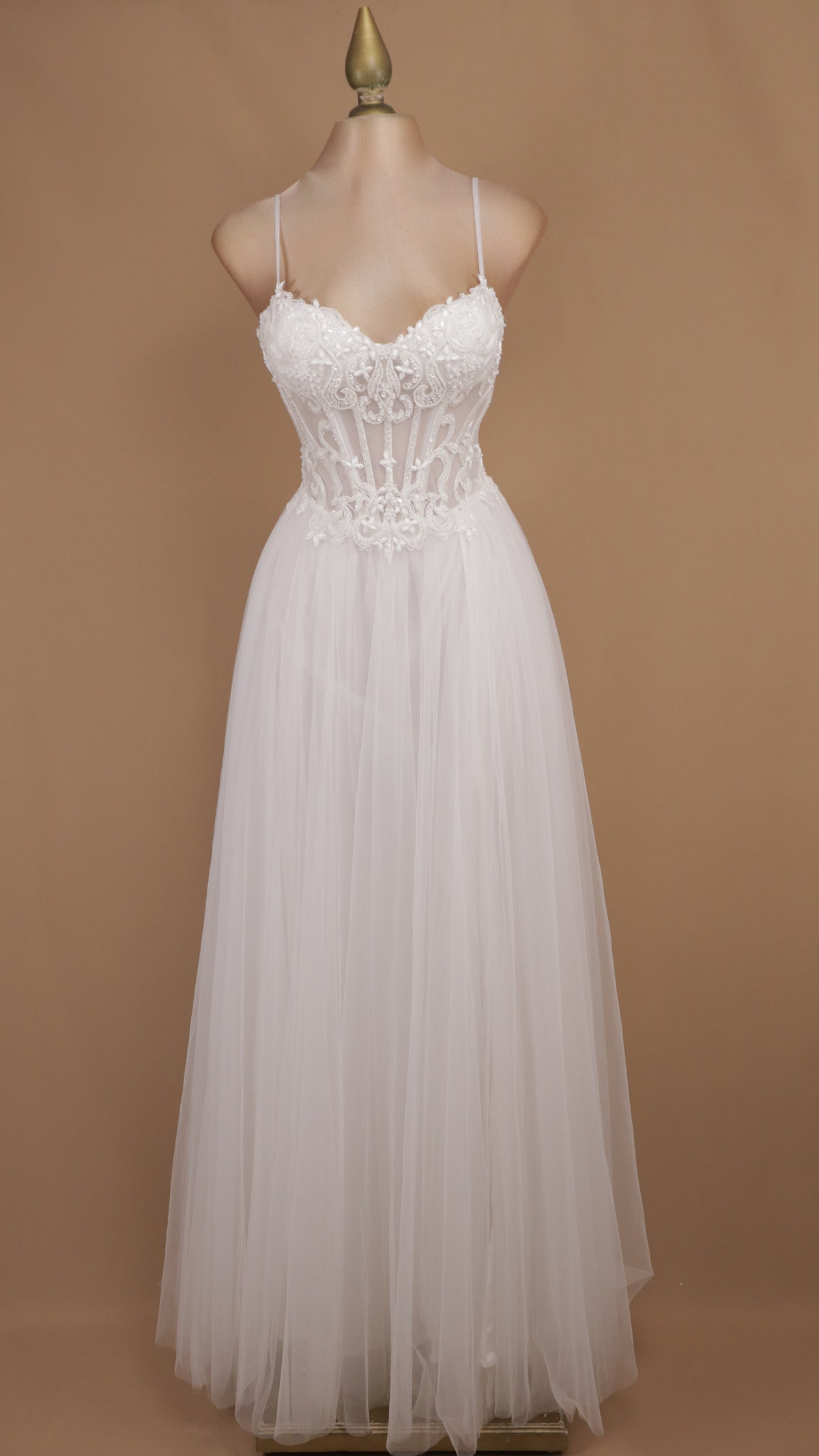 Vestido de novia con corsé translúcido de encaje, pedrería y falda fluida de tul