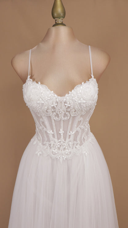 Vestido de novia con corsé translúcido de encaje, pedrería y falda fluida de tul