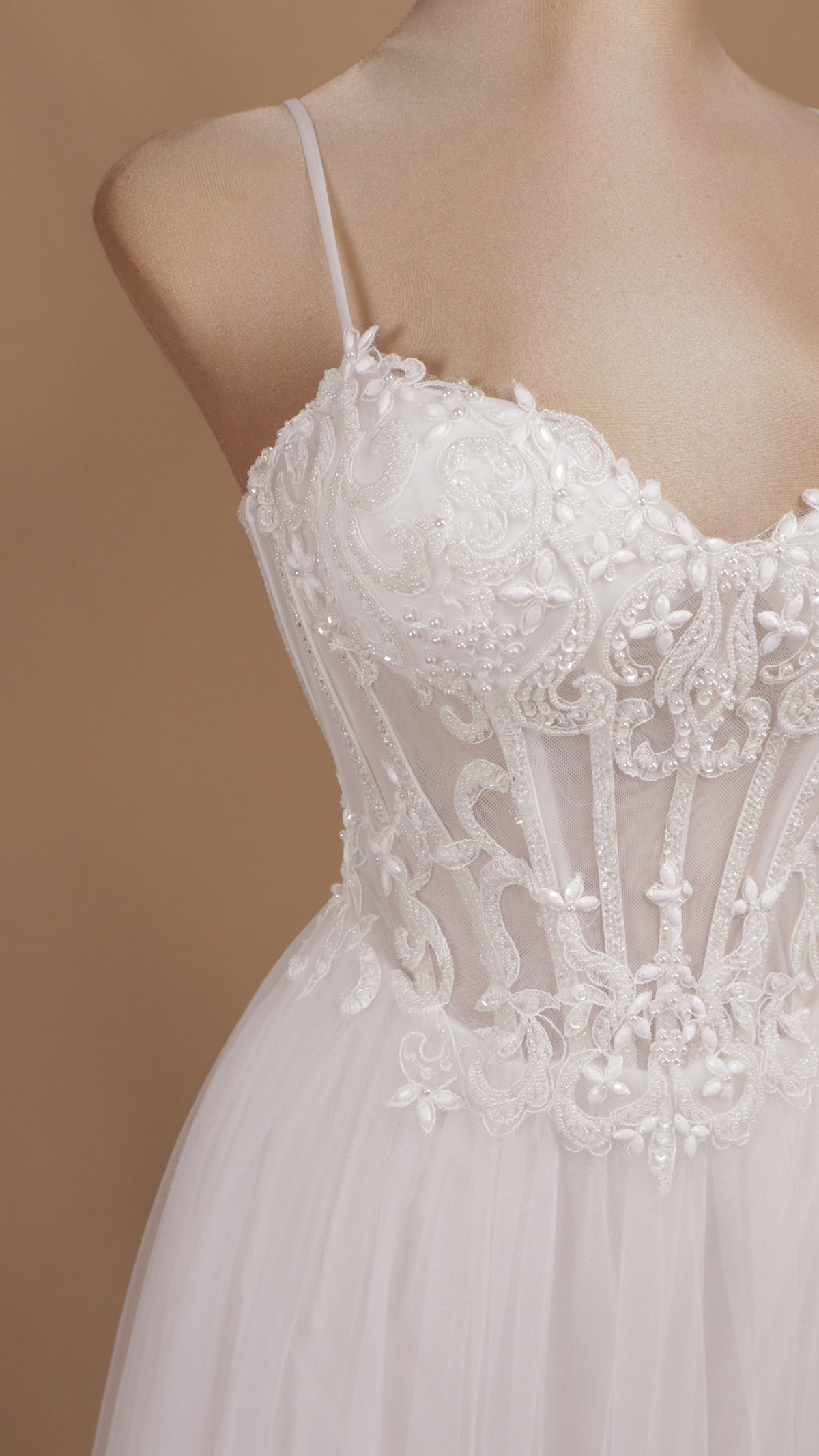 Vestido de novia con corsé translúcido de encaje, pedrería y falda fluida de tul