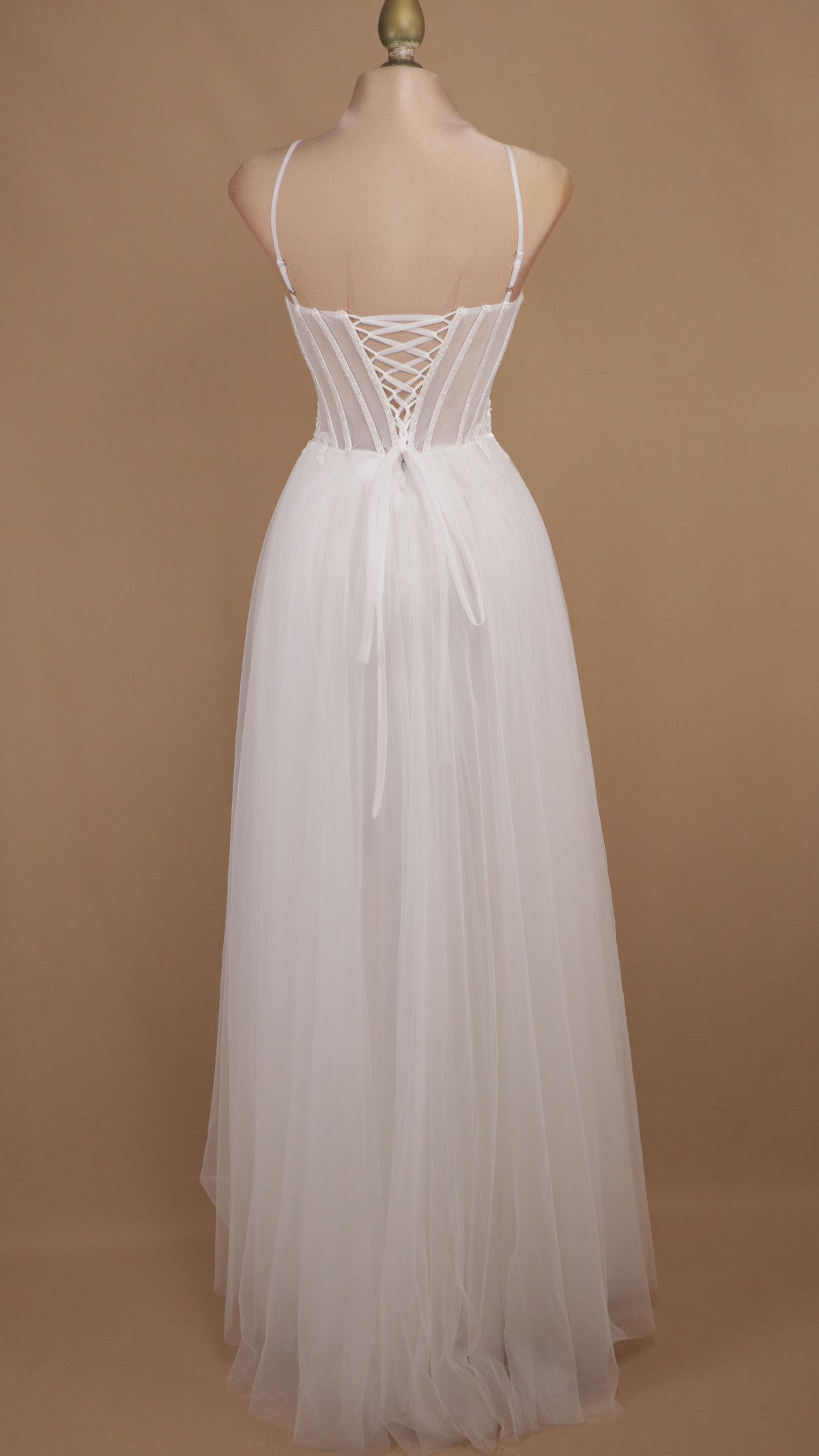 Vestido de novia con corsé translúcido de encaje, pedrería y falda fluida de tul