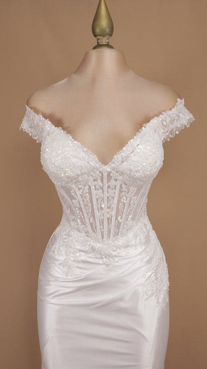Vestido de novia estilo sirena con corsé traslúcido y falda satinada con abertura