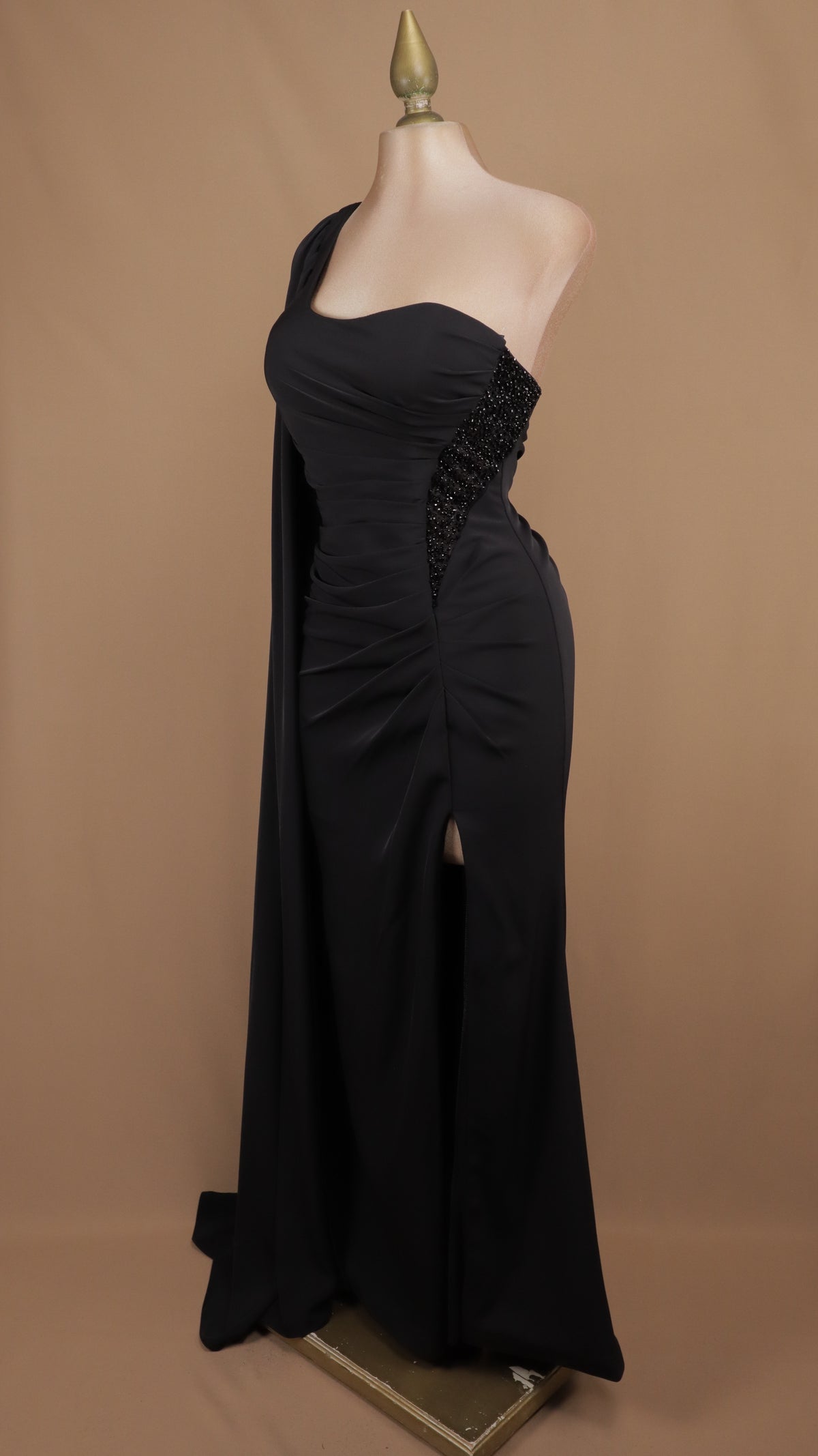 Vestido de gala largo de un solo hombro con estola drapeada y pedrería.