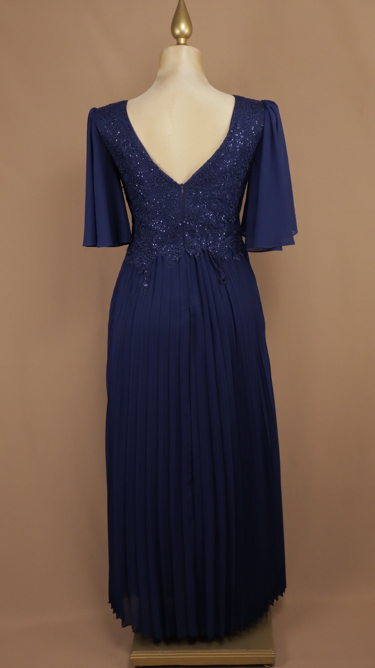 Vestido de noche en gasa plisada con encaje, bordado y mangas campanilla