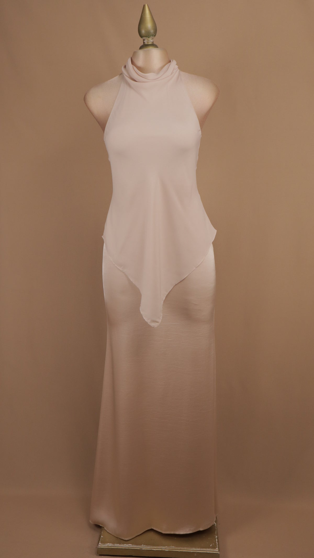 Vestido de noche largo minimalista de efecto superpuesto con cuello halter y bajo asimétrico.