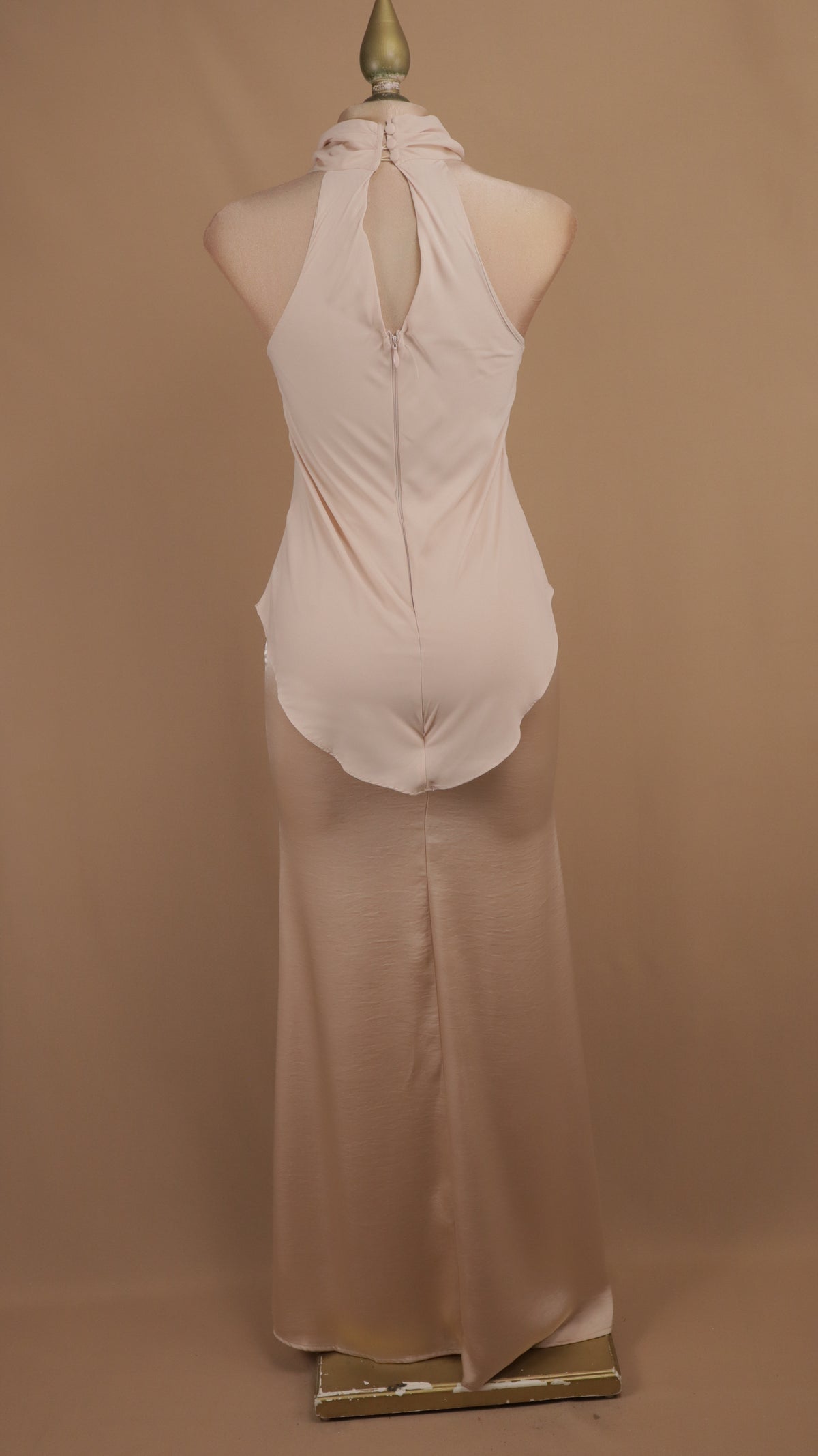 Vestido de noche largo minimalista de efecto superpuesto con cuello halter y bajo asimétrico.