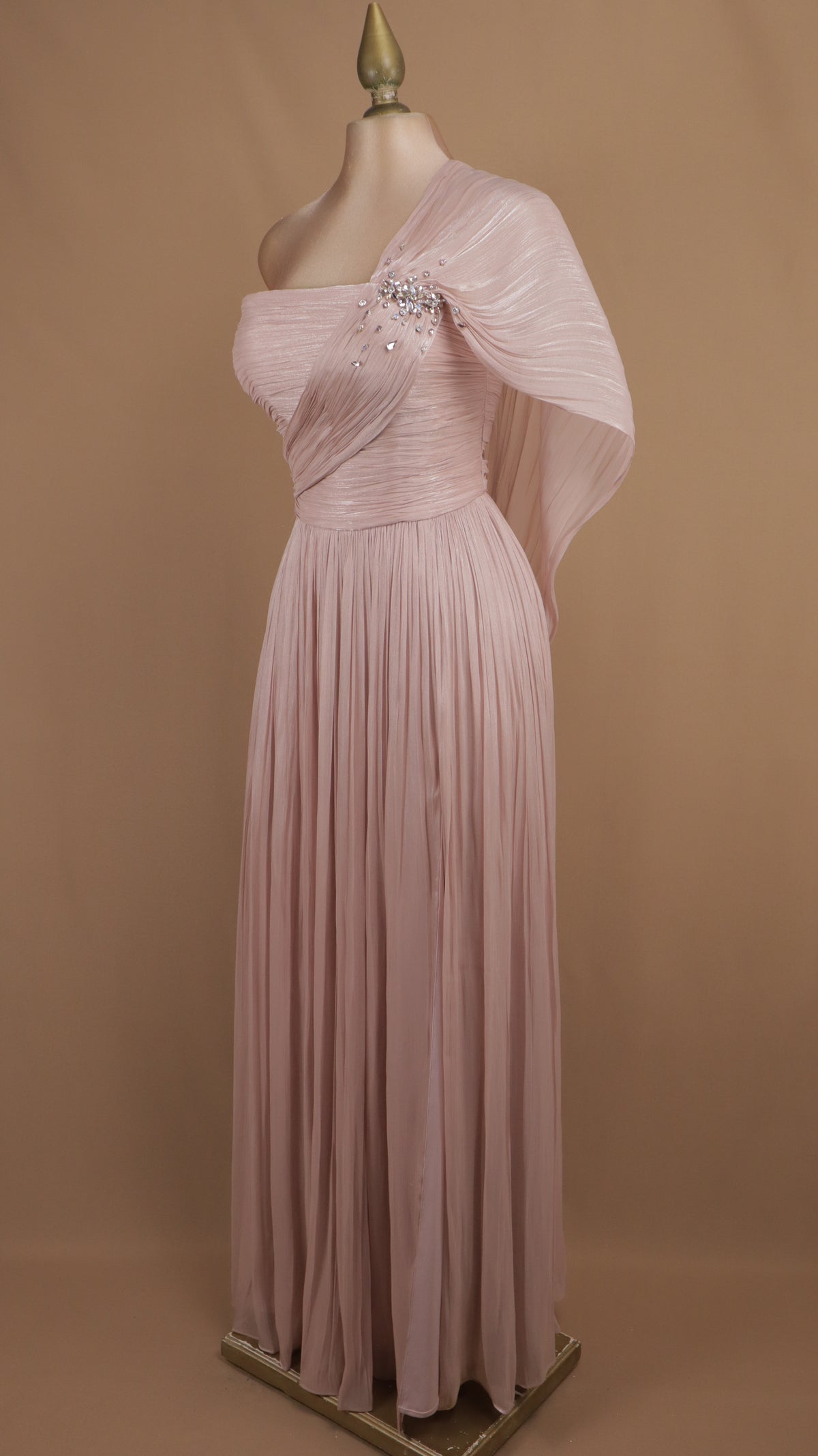 Vestido de gala largo plisado con escote y capa drapeada.