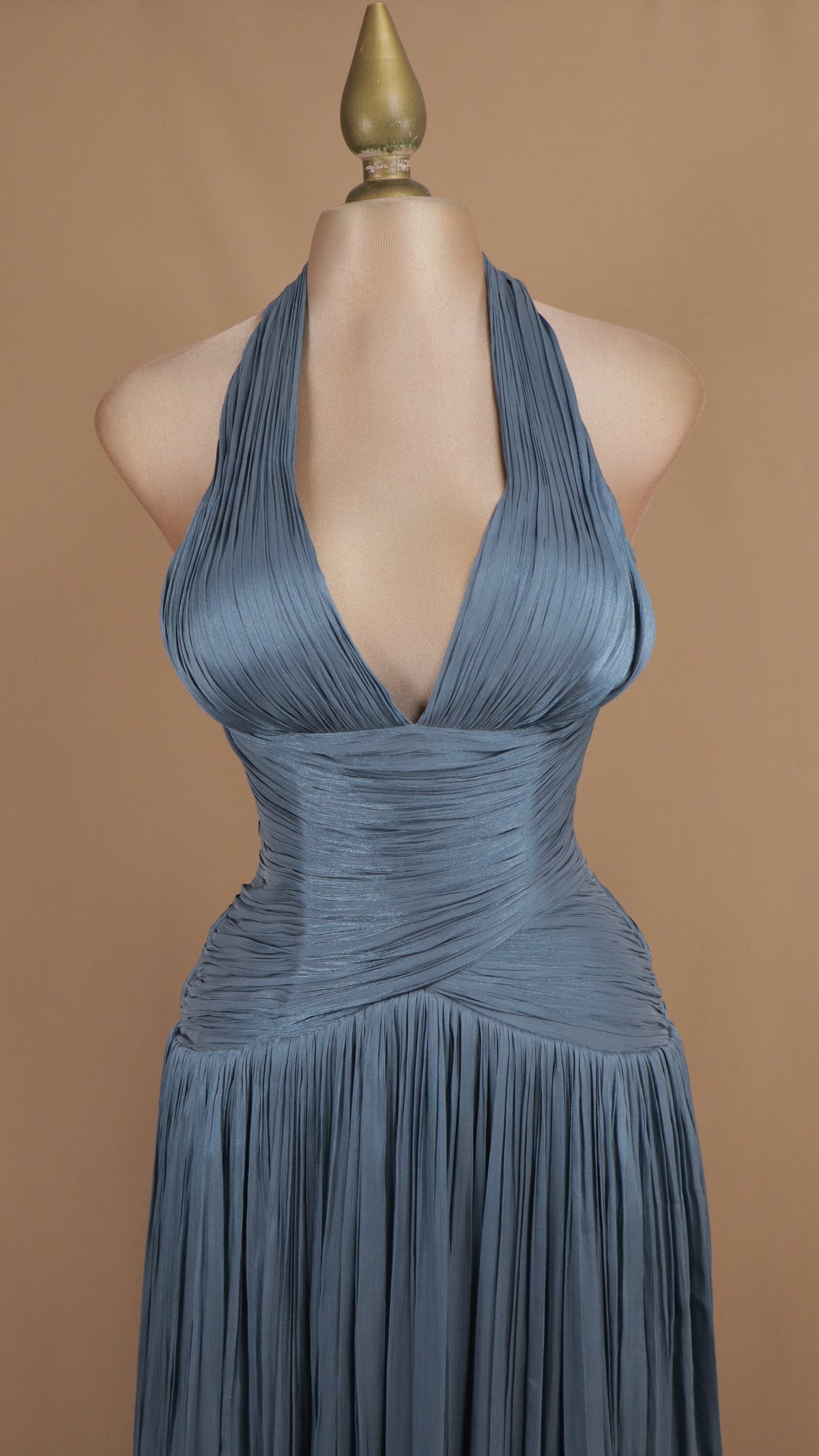 Vestido de noche largo plisado en pizarra con escote halter pronunciado y torso drapeado.