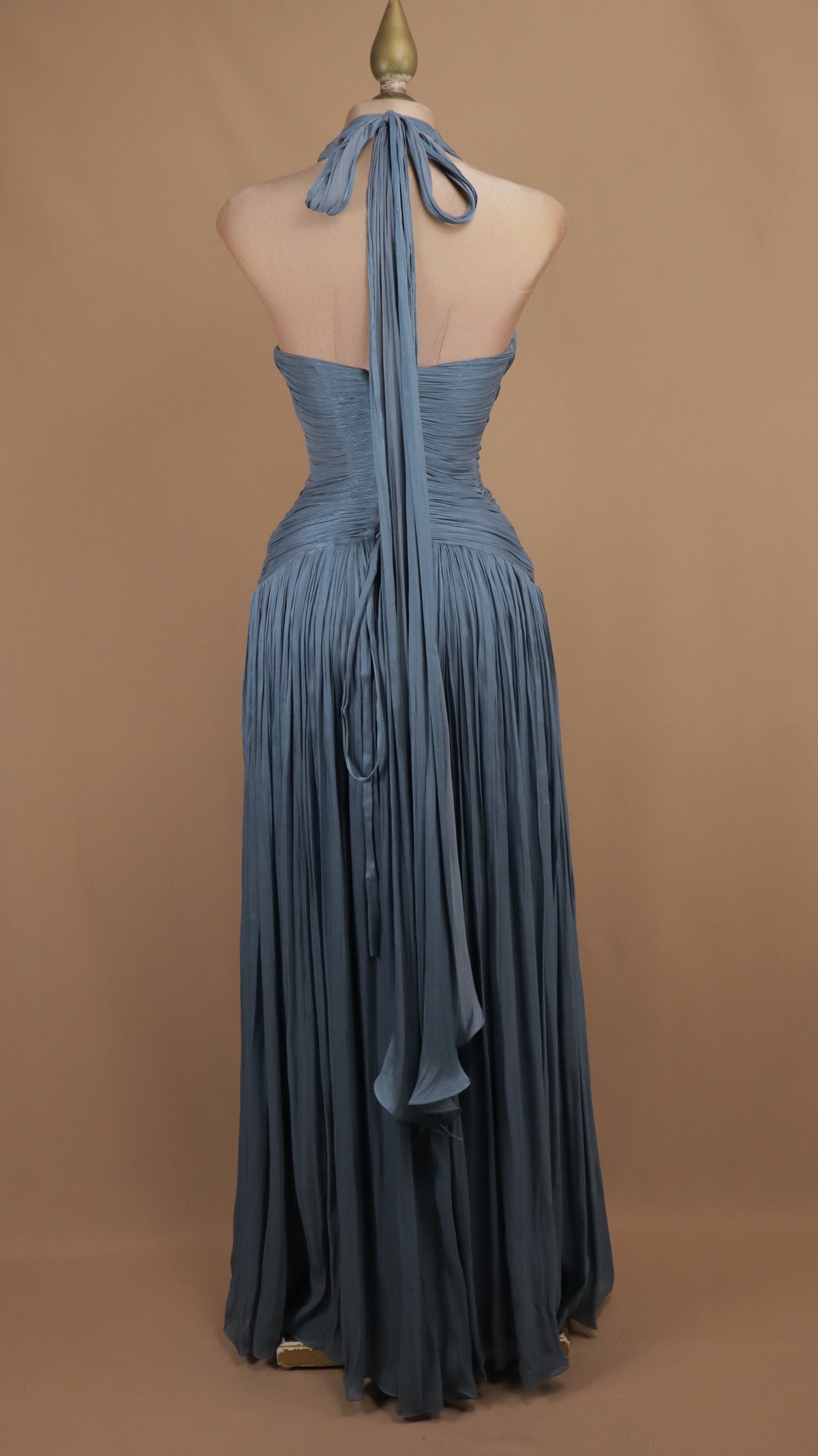 Vestido de noche largo plisado en pizarra con escote halter pronunciado y torso drapeado.